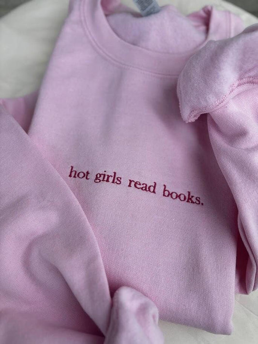 Embroidered sweatshirt with the phrase "Hot Girls Read Books" in stylish script. Cozy and chic, this sweatshirt celebrates book lovers with a bold statement. Perfect for bibliophiles who embrace both style and intellect. In various colors and sizes.