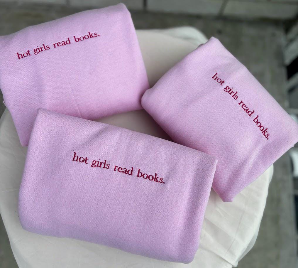 Embroidered sweatshirt with the phrase "Hot Girls Read Books" in stylish script. Cozy and chic, this sweatshirt celebrates book lovers with a bold statement. Perfect for bibliophiles who embrace both style and intellect. In various colors and sizes.