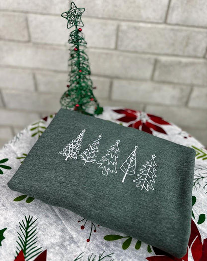 Green embroidered sweatshirt featuring an outline of four different types of Christmas trees. Perfect festive apparel for cozy winter days and holiday gatherings.