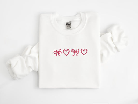 Soft embroidered sweatshirt featuring intricate hearts and bows on a cozy fabric. Perfect for Valentine&#39;s Day, romantic gifts, and cottagecore style lovers who enjoy warm, casual fashion with a touch of whimsy.