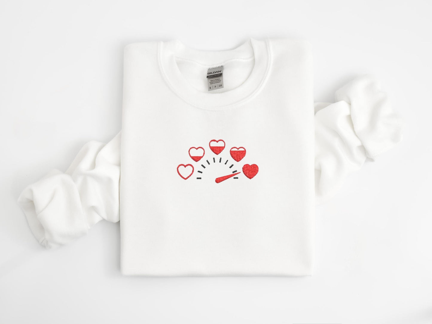 Embroidered sweatshirt featuring a creative speedometer design with five hearts instead of numbers, starting empty and gradually filling up to full. Perfect for cozy casual wear, unique gifts, or expressing love in a fun, modern style.